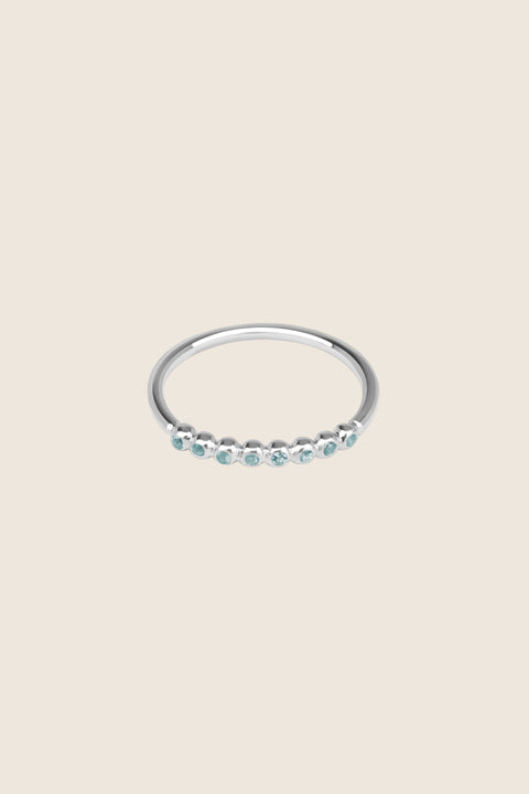 An elegant band ring featuring eight gemstones set in a refined beaded setting. Available with diamonds or topaz stones in monochrome or colorful combinations, this versatile design blends contemporary style with timeless elegance. Featuring 1.25 mm stones, it pairs beautifully with PLURES bands and the ILLE III ring. Discover refined versatility by UMIAR jewelry.