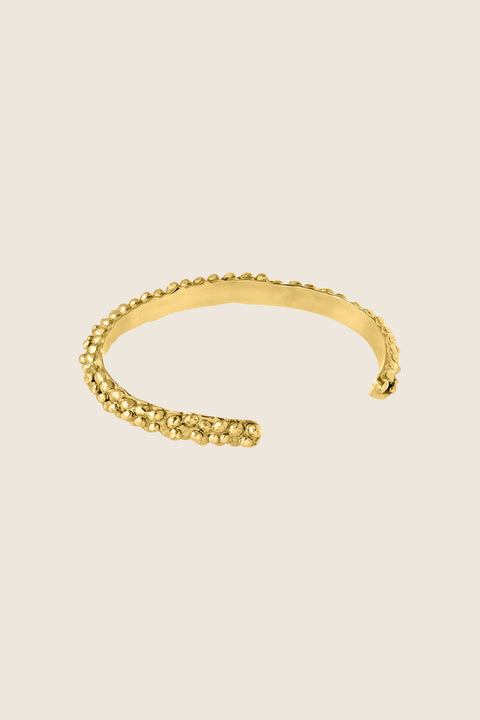 A rigid silver bangle with a distinctive granulated, speckled texture that beautifully reflects light and adds depth. Elegant worn alone or styled with the PELLO bracelet, it offers timeless sophistication and expressive design. A refined statement for lovers of unique, enduring jewelry. Discover sculptural elegance by UMIAR jewelry.