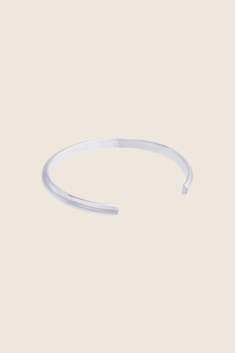 A minimalist bracelet crafted from a rigid silver tube with a distinctive semi-circular cross-section. Clean, elegant, and architectural, it offers a refined statement that complements both everyday and elevated styling. Discover timeless simplicity and modern form by UMIAR jewelry.