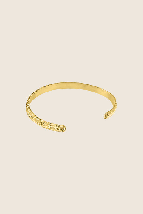A rigid silver bangle inspired by hammered textures, designed to reflect light and emphasize a sculptural, three-dimensional form. Elegant worn solo or styled with the CRATER bracelet, it offers refined strength and timeless appeal. Discover expressive craftsmanship and modern elegance by UMIAR jewelry.