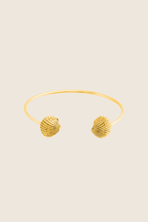 A rigid cuff bracelet adorned with realistic shell details that capture the essence of summer by the sea. Featuring shell elements measuring 15 × 13 mm, it blends decorative charm with classic elegance. Ideal for summer styling and refined everyday wear. Discover timeless seasonal design by UMIAR jewelry.