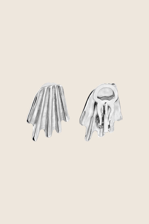 Elegant ear clips inspired by the form of broken shells. Featuring a sculptural, dynamic design, these statement clips add character and sophistication to any look. Measuring 20 x 27 mm, they are a striking choice for those who appreciate bold yet refined jewelry. Discover expressive elegance by UMIAR jewelry.