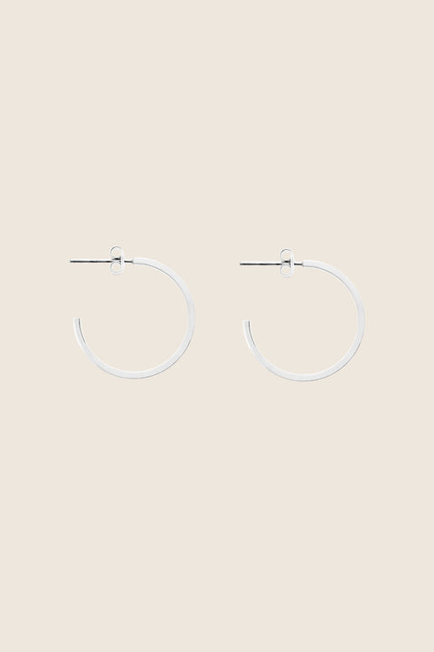 Delicate square-profile hoop earrings with a modern geometric character. Featuring a 23 mm diameter, they bring a contemporary edge to a classic form and can be worn alone or layered with ACTA MICRO. A timeless everyday essential. Discover refined minimalism by UMIAR jewelry.