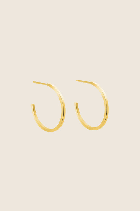 Delicate square-profile hoop earrings with a modern geometric character. Featuring a 23 mm diameter, they bring a contemporary edge to a classic form and can be worn alone or layered with ACTA MICRO. A timeless everyday essential. Discover refined minimalism by UMIAR jewelry.