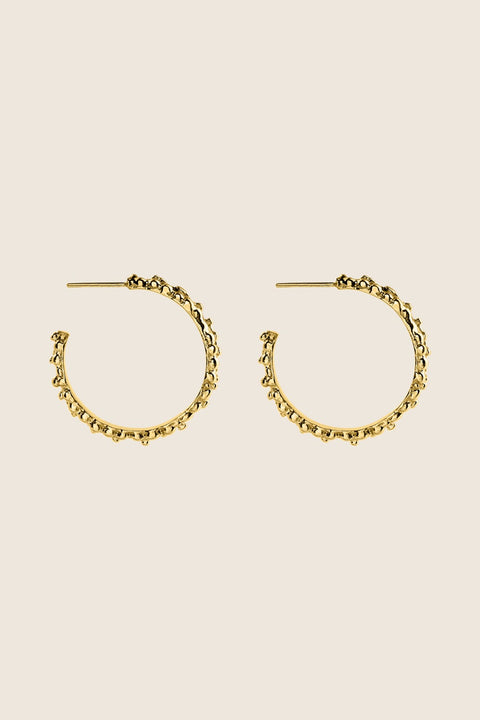 Large hoop earrings inspired by the sculptural surface of the moon, featuring a speckled, textured silver finish. With a 30 mm diameter, their irregular granulated structure reflects light beautifully, creating a bold yet elegant statement for evening wear. Discover expressive design by UMIAR jewelry.