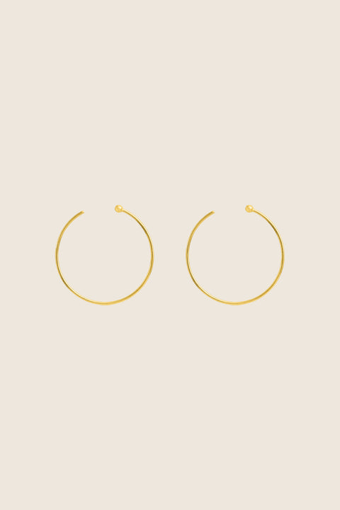 Minimalist hoop earrings made from fine wire with a subtle ball detail. Featuring a 30 mm diameter and a thread-through design with no clasp, they offer effortless elegance for everyday casual looks. A refined essential inspired by modern minimalism. Discover understated style by UMIAR jewelry.