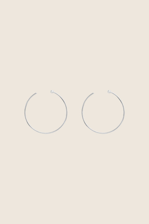 Minimalist hoop earrings made from fine wire with a subtle ball detail. Featuring a 30 mm diameter and a thread-through design with no clasp, they offer effortless elegance for everyday casual looks. A refined essential inspired by modern minimalism. Discover understated style by UMIAR jewelry.