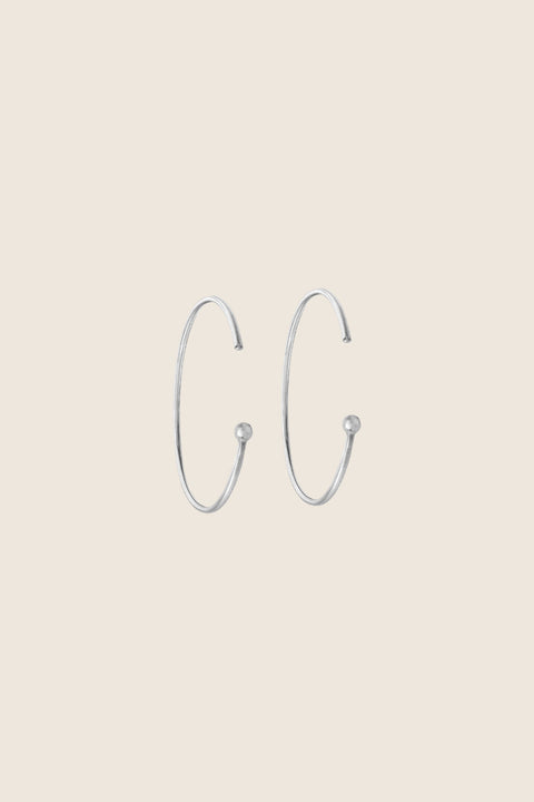 Minimalist hoop earrings made from fine wire with a subtle ball detail. Featuring a 30 mm diameter and a thread-through design with no clasp, they offer effortless elegance for everyday casual looks. A refined essential inspired by modern minimalism. Discover understated style by UMIAR jewelry.