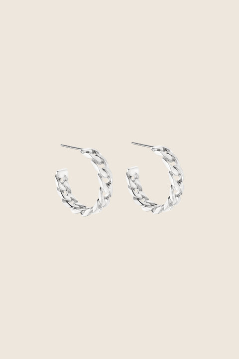 Hoop earrings inspired by the bold texture of a classic curb chain, featuring a 25 mm diameter. Combining 90s power dressing with modern elegance, this versatile design transitions seamlessly from day to night. A statement piece that adapts to every style. Discover confident design by UMIAR jewelry.