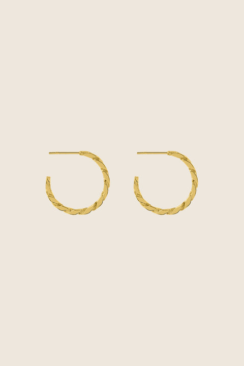 Hoop earrings inspired by the bold texture of a classic curb chain, featuring a 25 mm diameter. Combining 90s power dressing with modern elegance, this versatile design transitions seamlessly from day to night. A statement piece that adapts to every style. Discover confident design by UMIAR jewelry.