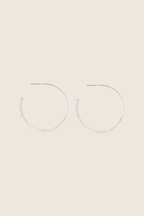 Hoop earrings with a distinctive evolving texture that shifts from hammered to smooth, polished finish. Featuring a bold 45 mm diameter, they offer an expressive yet elegant accent that enhances both minimalist and statement styling. Discover refined craftsmanship and modern design by UMIAR jewelry.
