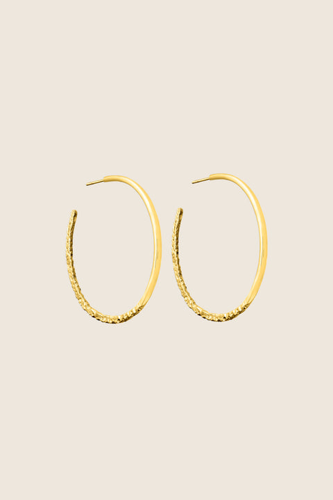 Hoop earrings with a distinctive evolving texture that shifts from hammered to smooth, polished finish. Featuring a bold 45 mm diameter, they offer an expressive yet elegant accent that enhances both minimalist and statement styling. Discover refined craftsmanship and modern design by UMIAR jewelry.