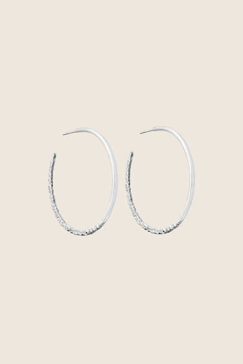 Hoop earrings with a distinctive evolving texture that shifts from hammered to smooth, polished finish. Featuring a bold 45 mm diameter, they offer an expressive yet elegant accent that enhances both minimalist and statement styling. Discover refined craftsmanship and modern design by UMIAR jewelry.