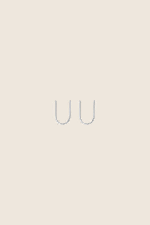 Handcrafted single-element earrings made from silver wire, shaped like the letter U. Minimal, discreet, and exceptionally comfortable, they are easy to wear by simply threading one end through the ear. A refined everyday design that subtly transforms when worn. Discover thoughtful minimalism by UMIAR jewelry.