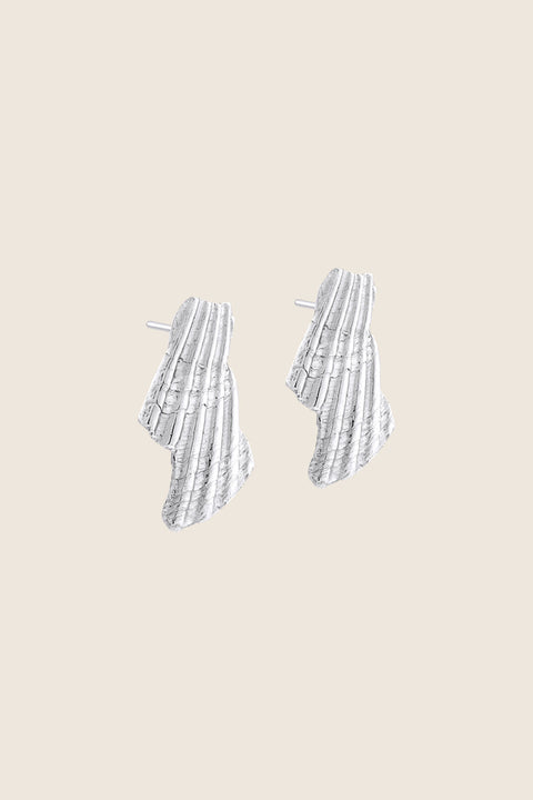 Expressive stud earrings inspired by broken shell forms bring a bold summer accent to your jewelry collection. Measuring 15 × 29 mm, they combine sculptural design with lightness, making them an ideal complement to warm-weather and holiday looks. Discover seasonal elegance by UMIAR jewelry.