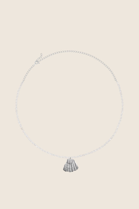 A refined choker necklace combining a silver broken shell pendant with natural pearls. Featuring an adjustable chain and a total length of 46 cm, it can be worn close to the neck or slightly lower for versatile styling. A modern marine accent that blends elegance with natural beauty. Discover contemporary seaside jewelry by UMIAR jewelry.