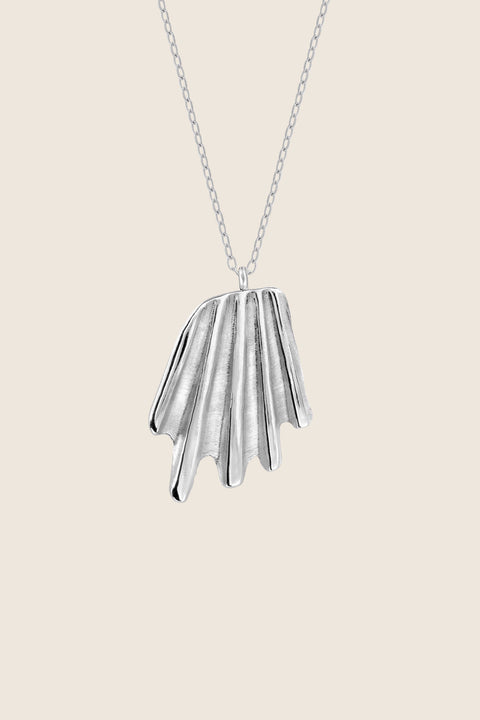 A striking pendant inspired by the form of a broken shell, suspended on a 50 cm silver chain. Its sculptural, dynamic shape makes it a bold yet elegant accent for summer looks. Designed for those who appreciate marine motifs in an unconventional, refined form. Discover expressive seaside design by UMIAR jewelry.