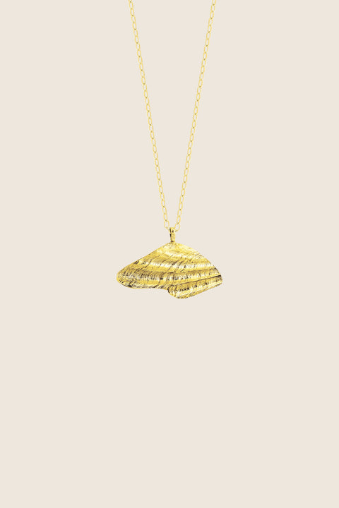 A delicate pendant inspired by the form of a broken shell, measuring 10 x 20 mm and suspended on a 40 cm chain. Combining organic texture with minimalist abstraction, this necklace captures timeless marine elegance. Ideal for summer looks and layering with the MARE II pendant. Discover refined seaside design by UMIAR jewelry.