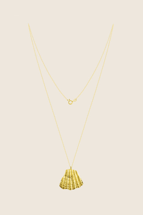 An elegant necklace featuring a large broken shell pendant measuring 25 x 25 mm, suspended on a 50 cm delicate chain. Combining organic texture with minimalist form, it is an ideal accent for summer looks. Beautiful worn alone or layered with the MARE I pendant. Discover refined marine elegance by UMIAR jewelry.