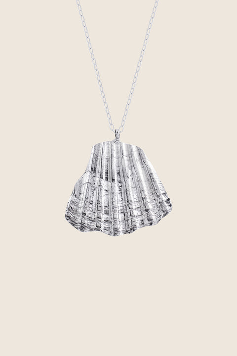 An elegant necklace featuring a large broken shell pendant measuring 25 x 25 mm, suspended on a 50 cm delicate chain. Combining organic texture with minimalist form, it is an ideal accent for summer looks. Beautiful worn alone or layered with the MARE I pendant. Discover refined marine elegance by UMIAR jewelry.