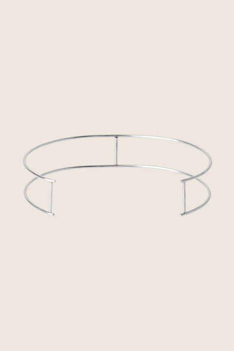A unique minimalist choker combining two ORA hoops with vertical crossbars. Handcrafted for individuality, this avant-garde design offers modern elegance and architectural form. A refined statement piece that enhances both casual and elevated styling. Discover contemporary minimalism by UMIAR jewelry.