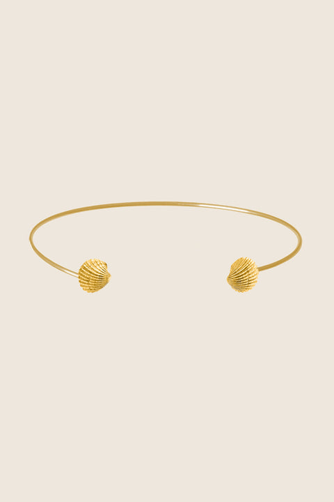 A minimalist choker inspired by the classic torques form, crafted as a rigid half-hoop with realistic shell details. Elegant and contemporary, it highlights the collarbones and adds a refined marine accent to summer looks. Discover modern jewelry with a seaside spirit by UMIAR jewelry.