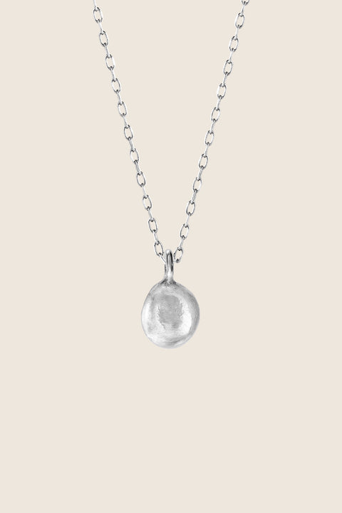 A distinctive pendant inspired by the organic shape of a droplet, suspended on a 50 cm chain. Each piece is subtly unique, highlighting its handcrafted character and individuality. A refined yet expressive accent for everyday and elegant styling. Discover authentic design by UMIAR jewelry.