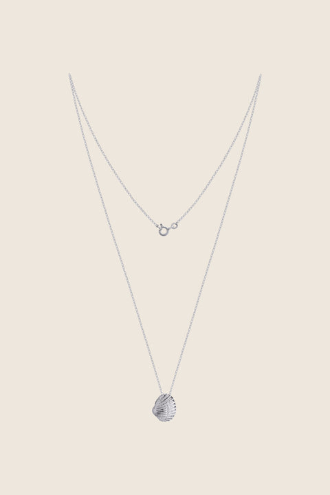 A delicate shell-shaped pendant measuring 15 x 10 mm, suspended on a 40 cm silver chain. Inspired by the ease of summer and the beauty of nature, this minimalist necklace works perfectly worn solo or layered with marine designs from the MARE collection. Discover subtle seaside elegance by UMIAR jewelry.