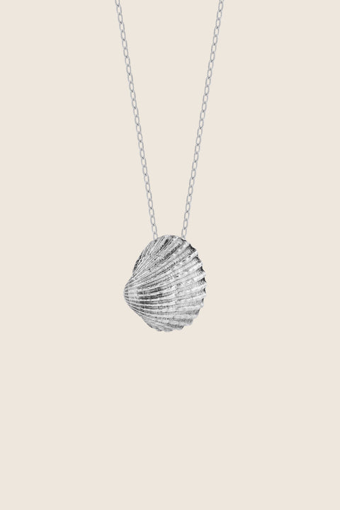 A delicate shell-shaped pendant measuring 15 x 10 mm, suspended on a 40 cm silver chain. Inspired by the ease of summer and the beauty of nature, this minimalist necklace works perfectly worn solo or layered with marine designs from the MARE collection. Discover subtle seaside elegance by UMIAR jewelry.