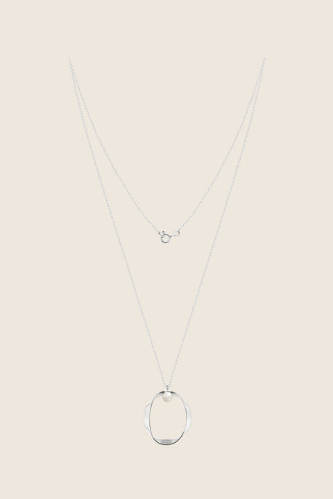 A minimalist pendant inspired by feminine intimacy, crafted from a sculptural silver ribbon and accented with a natural pearl. Suspended on a 50 cm silver chain, this refined design celebrates the beauty of the body through symbolic form and artistic craftsmanship. Discover expressive minimalism by UMIAR jewelry.