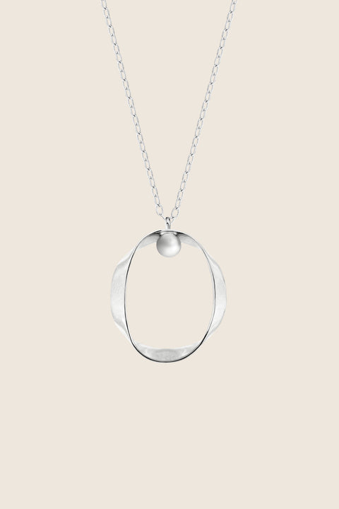 A minimalist silver pendant inspired by feminine intimacy, designed as a sculptural, three-dimensional form made from a softly contoured ribbon. Suspended on a 50 cm silver chain, it celebrates the beauty of the body through symbolic design and refined craftsmanship. Discover expressive elegance by UMIAR jewelry.