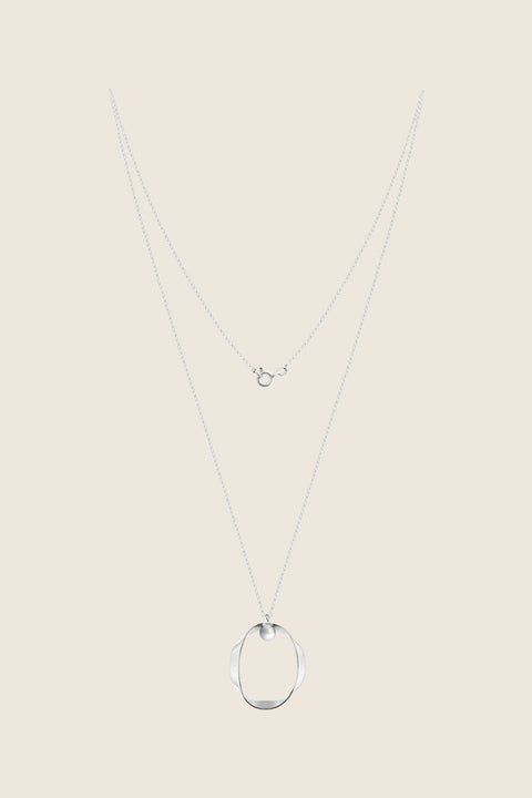 A minimalist silver pendant inspired by feminine intimacy, designed as a sculptural, three-dimensional form made from a softly contoured ribbon. Suspended on a 50 cm silver chain, it celebrates the beauty of the body through symbolic design and refined craftsmanship. Discover expressive elegance by UMIAR jewelry.