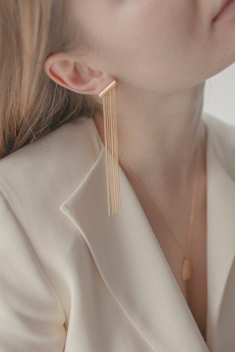 Decorative stud earrings featuring delicate dangling chains that sway gracefully with movement. An elegant, eye-catching design that adds fluidity and sophistication to any outfit, from daywear to evening styling. Discover refined elegance and modern detail by UMIAR jewelry.