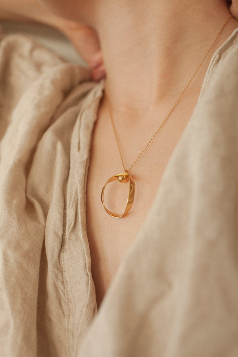 A minimalist silver pendant inspired by feminine intimacy, designed as a sculptural, three-dimensional form made from a softly contoured ribbon. Suspended on a 50 cm silver chain, it celebrates the beauty of the body through symbolic design and refined craftsmanship. Discover expressive elegance by UMIAR jewelry.