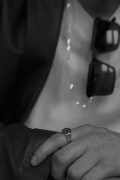 A minimalist square signet ring with softly cut corners and a smooth, polished finish. Designed as a unisex piece, it combines modern simplicity with timeless elegance. Featuring a 12 × 12 mm face, it is a refined everyday accessory for those who value clean, contemporary design. Discover understated sophistication by UMIAR jewelry.