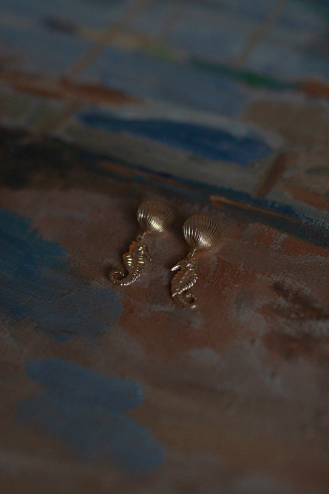 Stud earrings in the shape of a seahorse and shell add a joyful, summer-inspired accent to your jewelry collection. Measuring 22 × 15 mm, they are ideal for holiday looks and seaside styling. A playful yet elegant must-have for summer adventures. Discover seasonal design by UMIAR jewelry.
