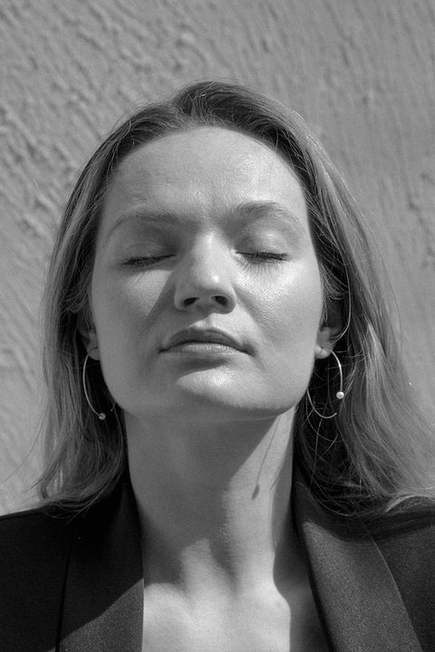 Large minimalist hoop earrings made from fine wire and accented with a natural pearl. Featuring a 45 mm diameter and a thread-through design with no clasp, they offer a refined yet expressive look. A modern statement piece perfect for special occasions. Discover contemporary elegance by UMIAR jewelry.