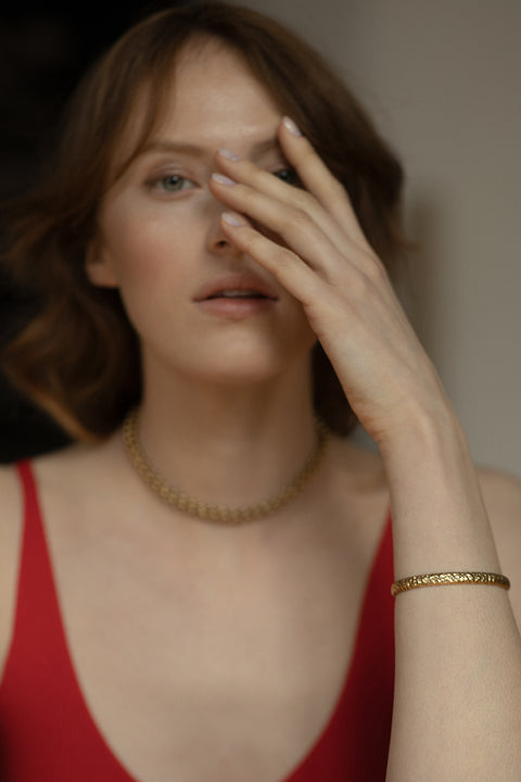 A rigid silver bangle inspired by hammered textures, designed to reflect light and emphasize a sculptural, three-dimensional form. Elegant worn solo or styled with the CRATER bracelet, it offers refined strength and timeless appeal. Discover expressive craftsmanship and modern elegance by UMIAR jewelry.