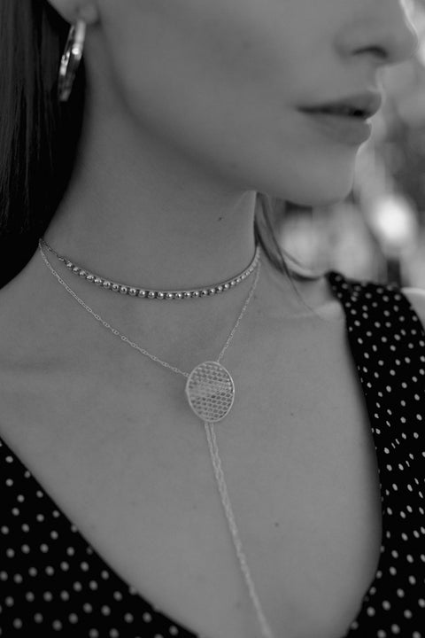 A decorative choker necklace featuring a studded half-hoop and adjustable length for a perfect fit. Elegant yet flirtatious, it highlights the neck and décolletage with refined character. With a total length of 40 cm, it adapts effortlessly to various styling needs. Discover expressive elegance by UMIAR jewelry.