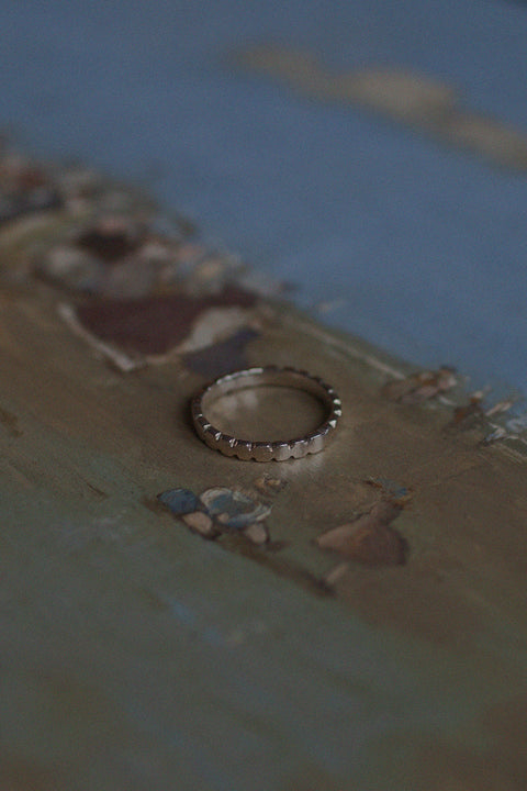 A decorative band ring featuring an irregular edge that brings a modern accent to a classic form. Elegant yet distinctive, it is designed for both everyday wear and special occasions. A timeless piece that balances tradition with contemporary character. Discover refined design by UMIAR jewelry.