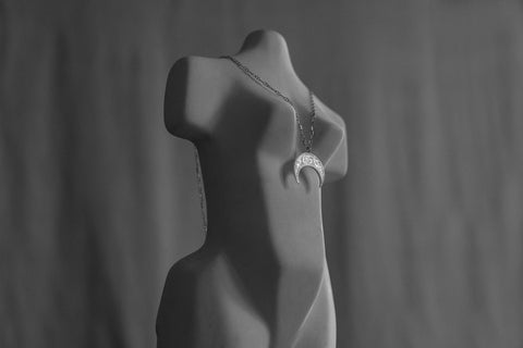 A lunula moon pendant inspired by ancient Roman symbolism, representing femininity and good fortune. Decoratively detailed and vertically proportioned, it is suspended on a 50 cm chain and measures 22 x 18 mm. A distinctive piece that combines history with contemporary elegance. Discover meaningful design by UMIAR jewelry.