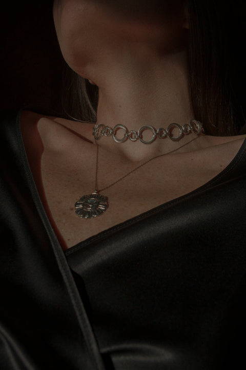 A large flower-shaped pendant necklace inspired by vintage aesthetics, suspended on a refined 50 cm silver chain. Featuring a 27 mm decorative pendant, it combines bold floral character with elegant simplicity. A striking choice for lovers of expressive design and high-quality craftsmanship. Discover timeless statement jewelry by UMIAR jewelry.