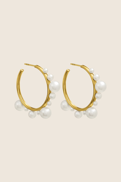 Discover the elegant and expressive hoop earrings adorned with natural pearls of varying sizes by UMIAR Jewellery. Their unique design makes them not only a beautiful accessory but also a bold statement piece in your look. Wear them on their own or paired with GEMINA inserts. Handcrafted from noble materials — 925 sterling silver and 24k gold-plated sterling silver. Find your unique style today!