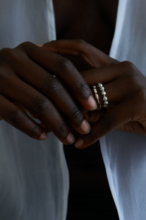 Discover the elastic jeweller’s-cord ring by UMIAR Jewellery, crafted from round beads and delicate rock crystals. Subtle and elegant, it adjusts perfectly to the finger, making it a refined accent for any look. Handcrafted with care, available in 925 sterling silver and 24k gold-plated 925 silver. Order now and add a touch of sophistication to your collection!