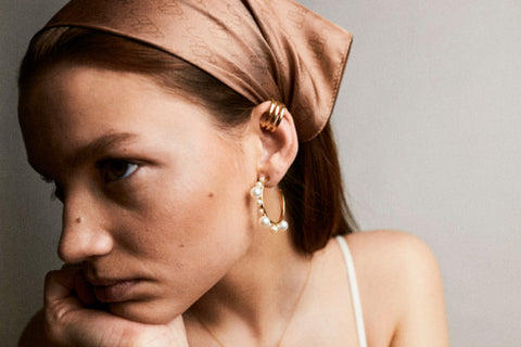 Discover the silk scarf with an original UMIAR Jewellery design. Its caramel-brown colour palette adds a touch of elegance. Crafted from 100% silk twill, this unique scarf makes a perfect, beautifully packaged gift. Experience the blend of thoughtful design and refined craftsmanship in UMIAR’s distinctive creations.