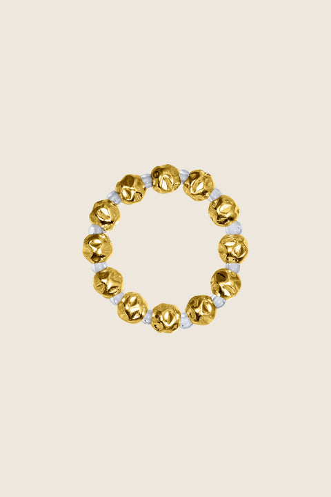 Discover the elastic jeweller’s-cord ring by UMIAR Jewellery, crafted from round beads and delicate rock crystals. Subtle and elegant, it adjusts perfectly to the finger, making it a refined accent for any look. Handcrafted with care, available in 925 sterling silver and 24k gold-plated 925 silver. Order now and add a touch of sophistication to your collection!