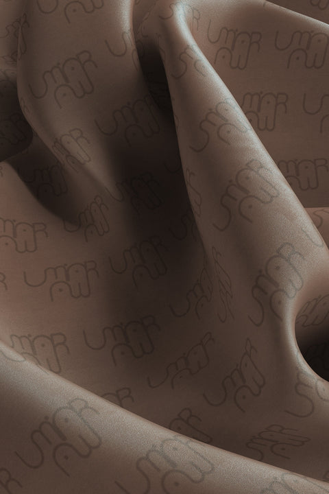 Discover the silk scarf with an original UMIAR Jewellery design. Its caramel-brown colour palette adds a touch of elegance. Crafted from 100% silk twill, this unique scarf makes a perfect, beautifully packaged gift. Experience the blend of thoughtful design and refined craftsmanship in UMIAR’s distinctive creations.