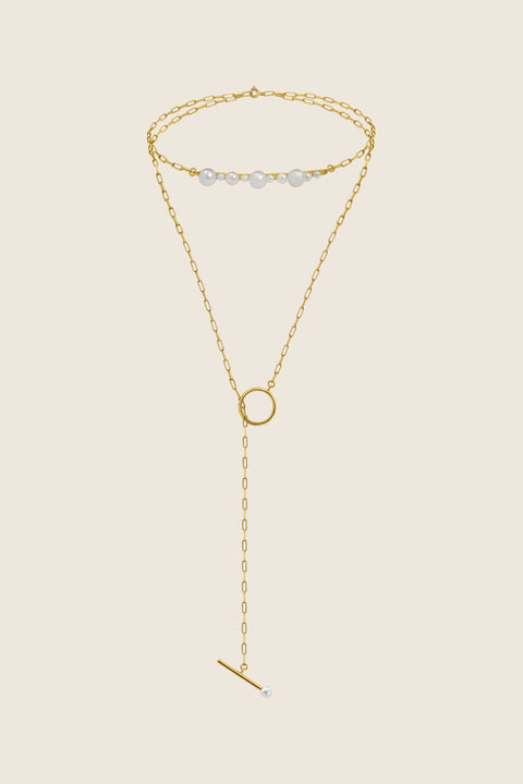 An exceptionally striking choker necklace from UMIAR Jewellery, showcasing a beautiful variety of natural pearls, a delicate chain, and an asymmetrical circular pendant. Handcrafted with care, it is available in both 925 sterling silver and 24k gold-plated sterling silver. This blend of design and craftsmanship creates a unique piece of jewellery that radiates elegance and style.
