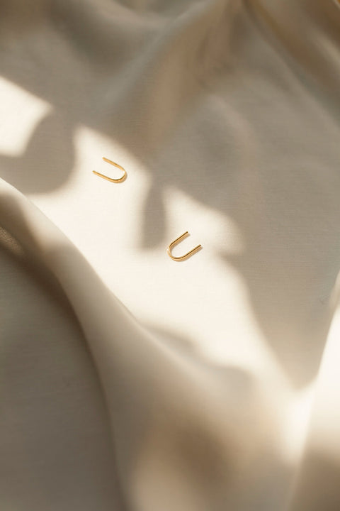 Handcrafted single-element earrings made from silver wire, shaped like the letter U. Minimal, discreet, and exceptionally comfortable, they are easy to wear by simply threading one end through the ear. A refined everyday design that subtly transforms when worn. Discover thoughtful minimalism by UMIAR jewelry.