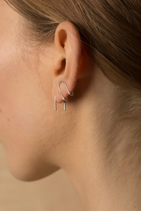 Handcrafted single-element earrings made from silver wire, shaped like the letter U. Minimal, discreet, and exceptionally comfortable, they are easy to wear by simply threading one end through the ear. A refined everyday design that subtly transforms when worn. Discover thoughtful minimalism by UMIAR jewelry.